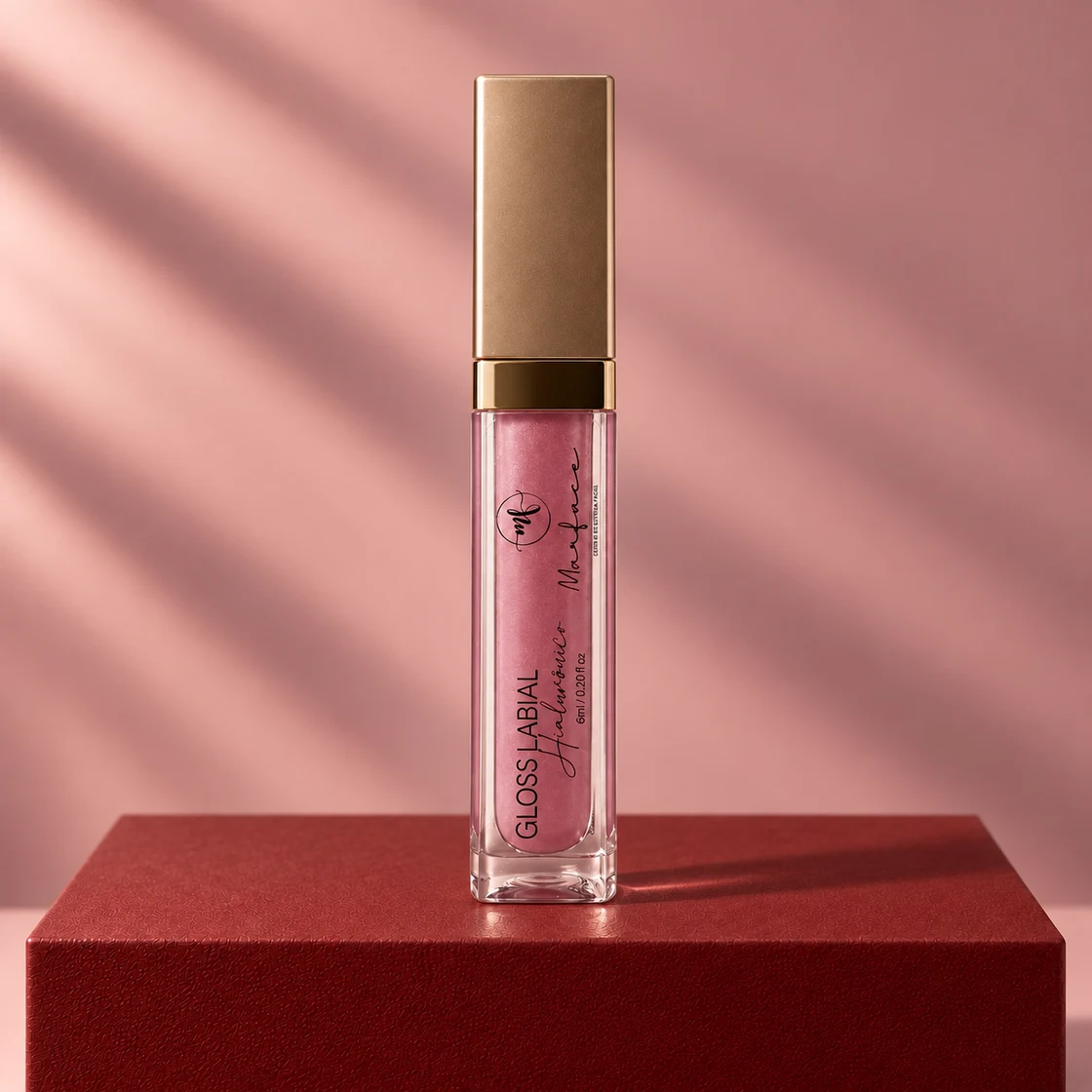 Gloss Labial Hialurônico Marface sobre uma base bordô, com fundo rosado